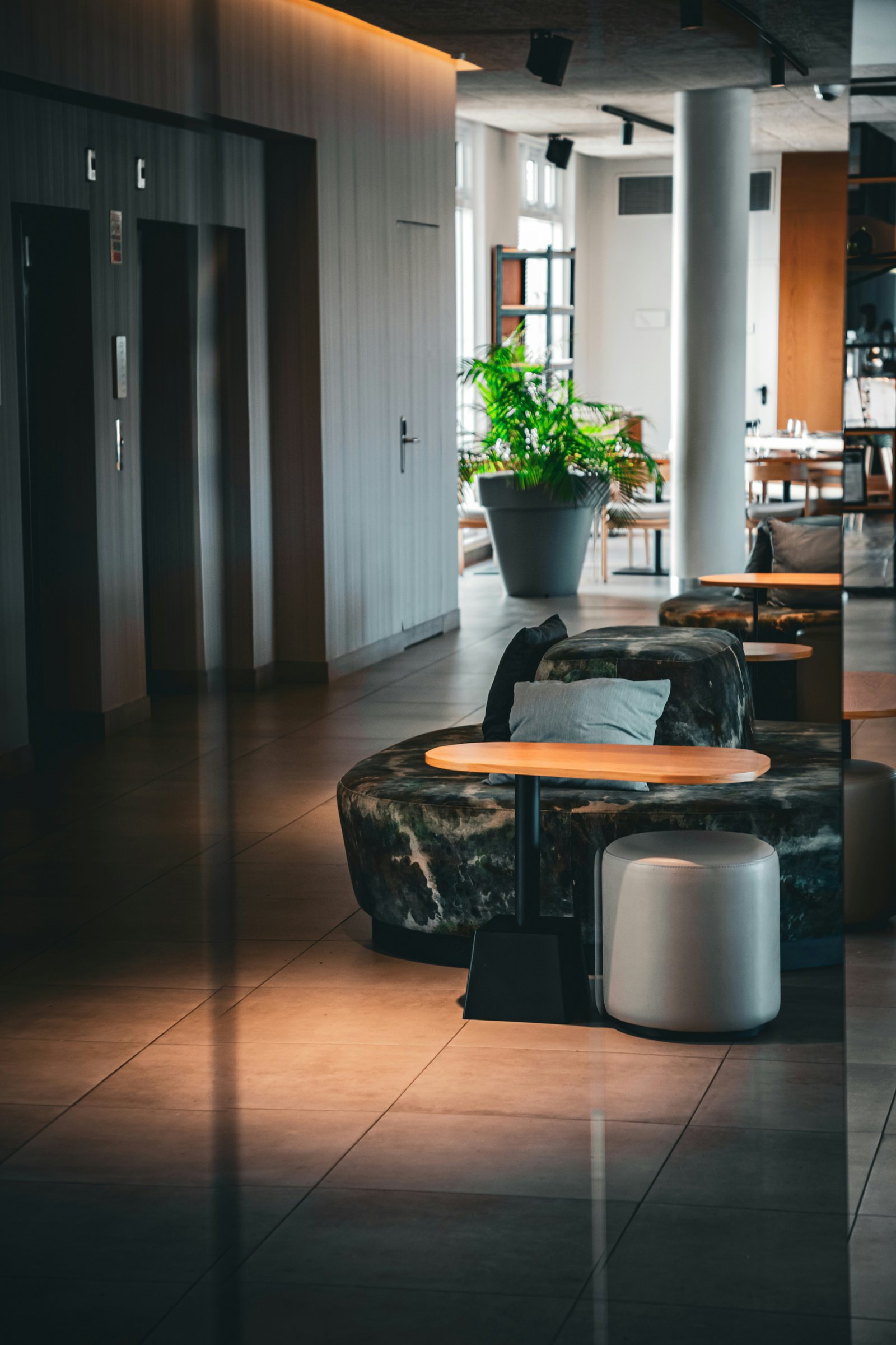 A contemporary Portuguese hotel lounge with sculptural seating, timber tables and plants