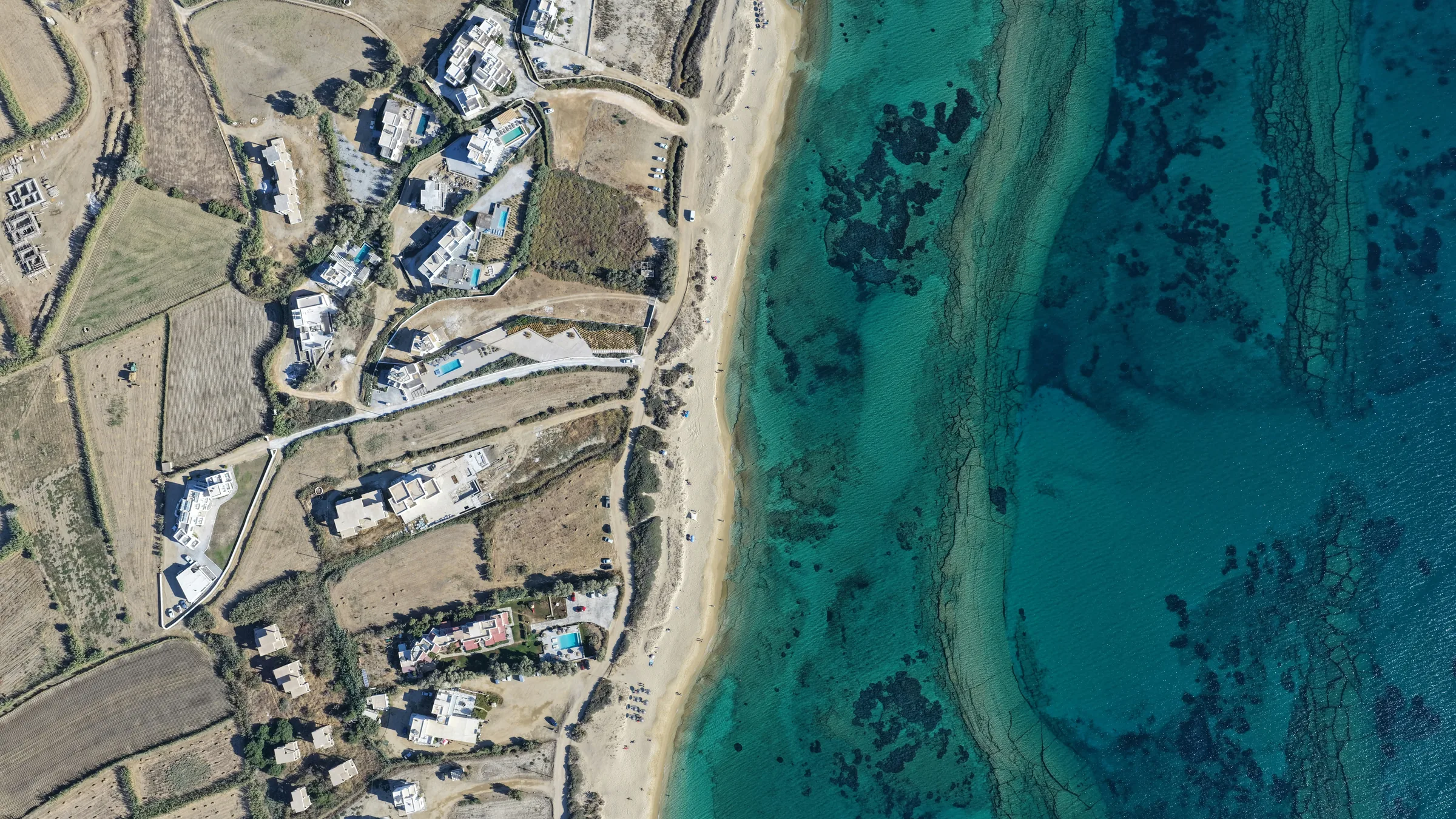 An aerial view of a Mediterranean shoreline with clear turquoise water